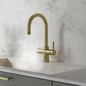 a swan neck champagne gold boiling water tap on a white kitchen countertop