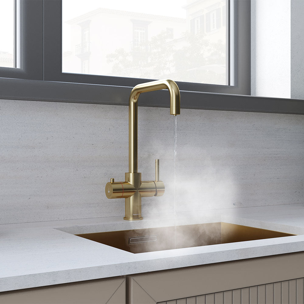 a brushed brass copper boiling water tap on a white kitchen countertop