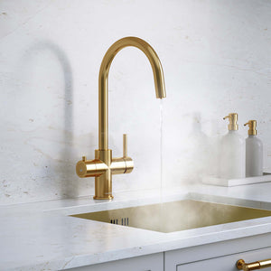 a gold swan neck boiling water tap on a white kitchen countertop