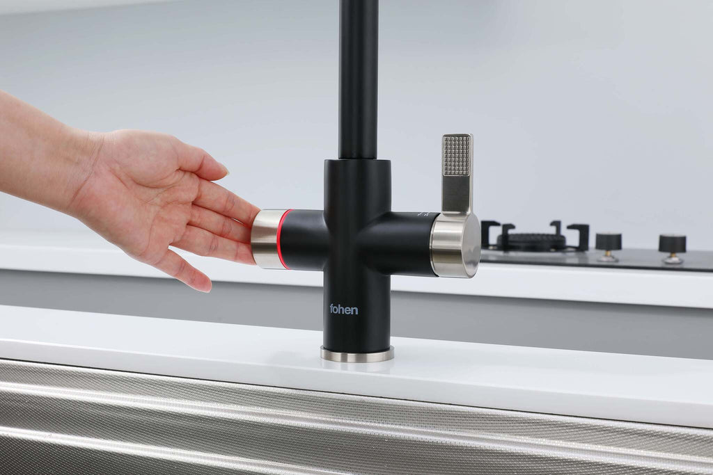 Person turning a black kitchen faucet with a silver handle on a white countertop.