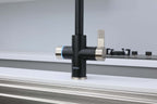 Black kitchen faucet with silver handles on a white countertop