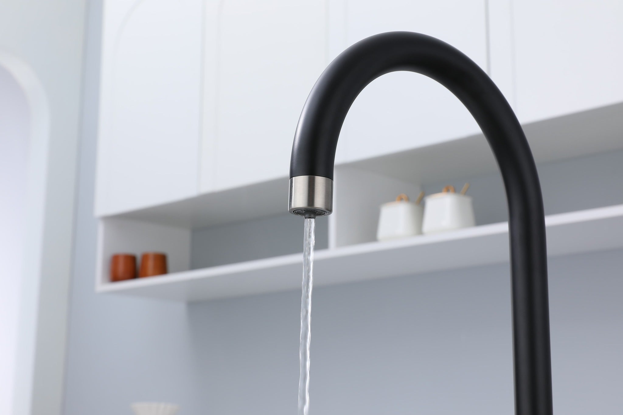Black kitchen faucet with water flowing in a modern kitchen setting
