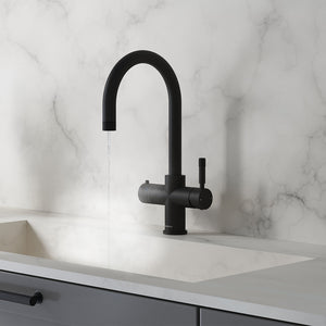 a matt black swan neck boiling water tap on a white kitchen countertop