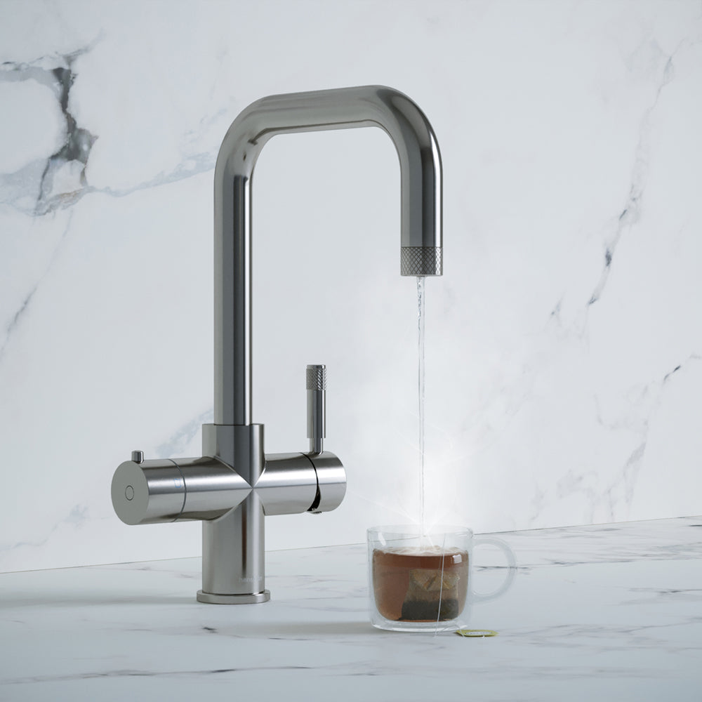 a chrome square-shaped boiling water tap dispensing hot water to a cup of tea