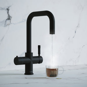 a matt black square-shaped boiling water tap dispensing hot water to a cup of tea