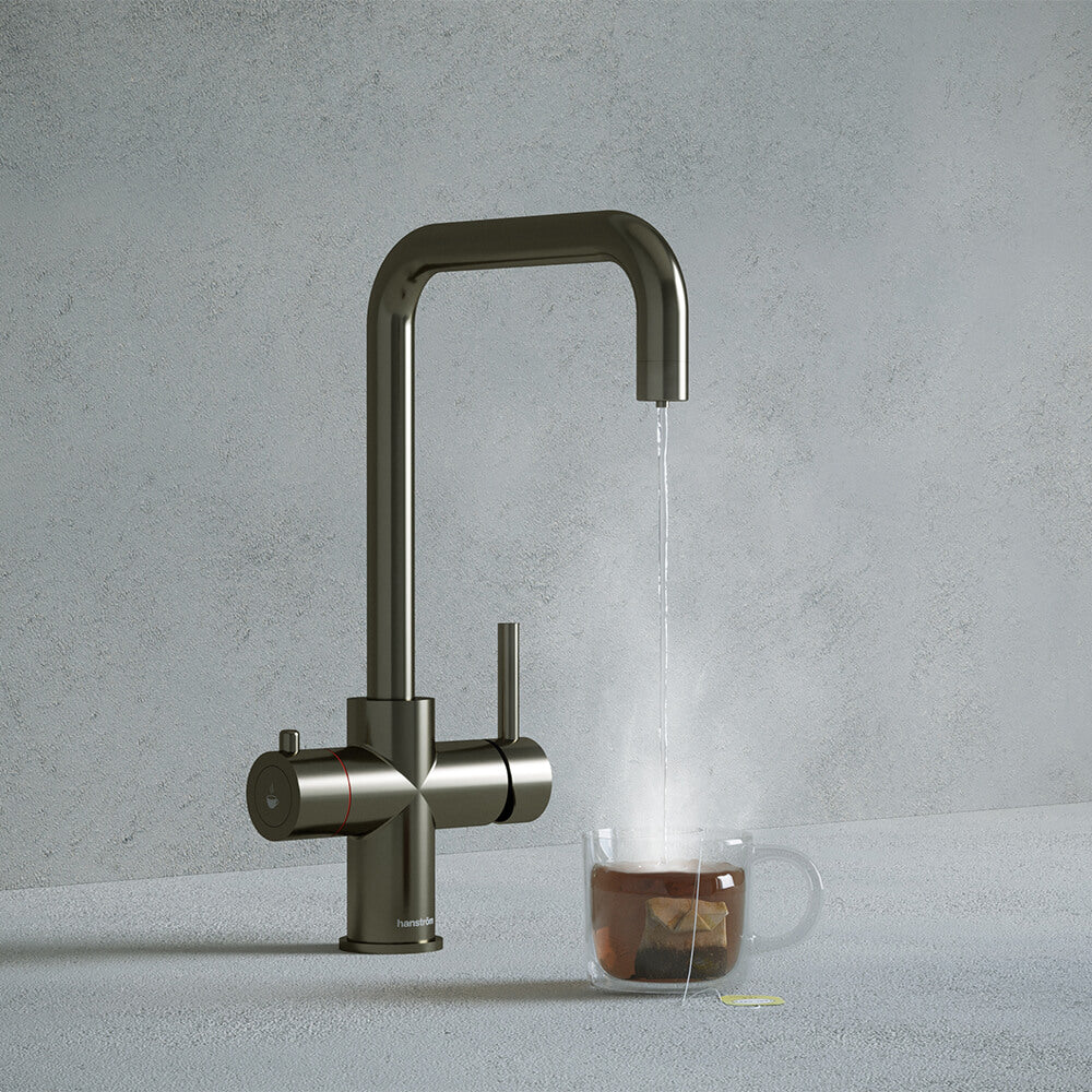 a gunmetal grey square-shaped boiling water tap dispensing hot water to a cup of tea