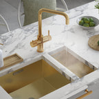 a brushed gold square-shaped boiling water tap on a white kitchen countertop