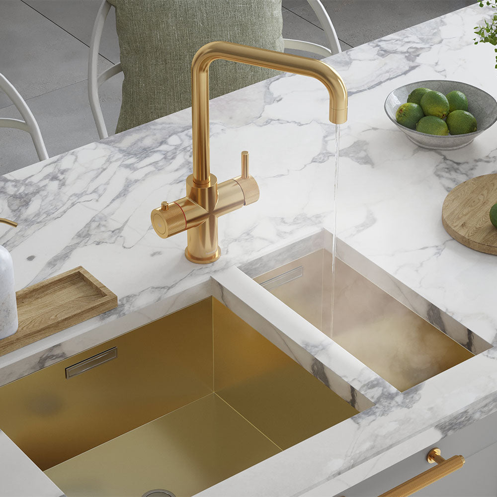 a brushed gold square-shaped boiling water tap on a white kitchen countertop