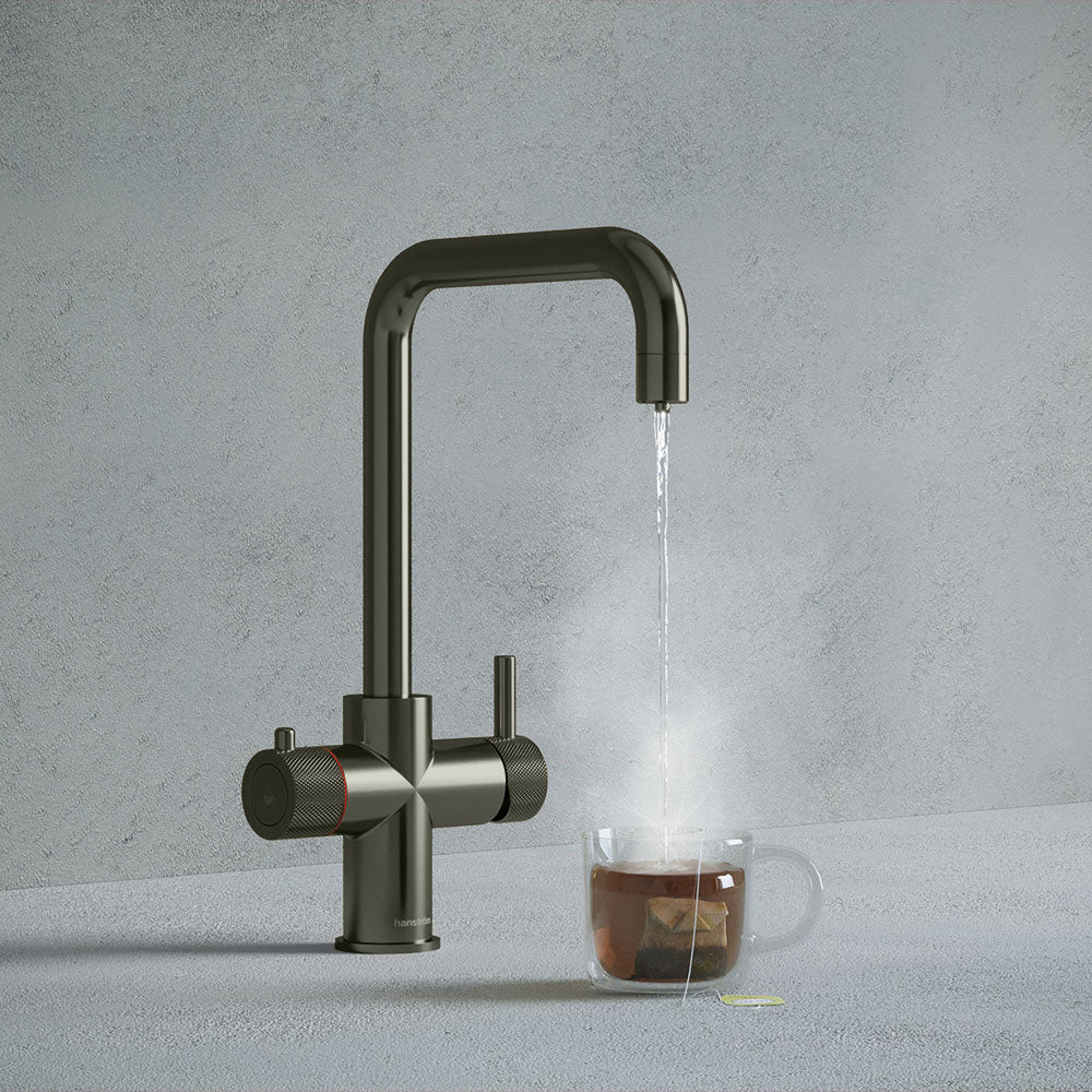 a gunmetal grey square-shaped boiling water tap dispensing hot water to a cup of tea