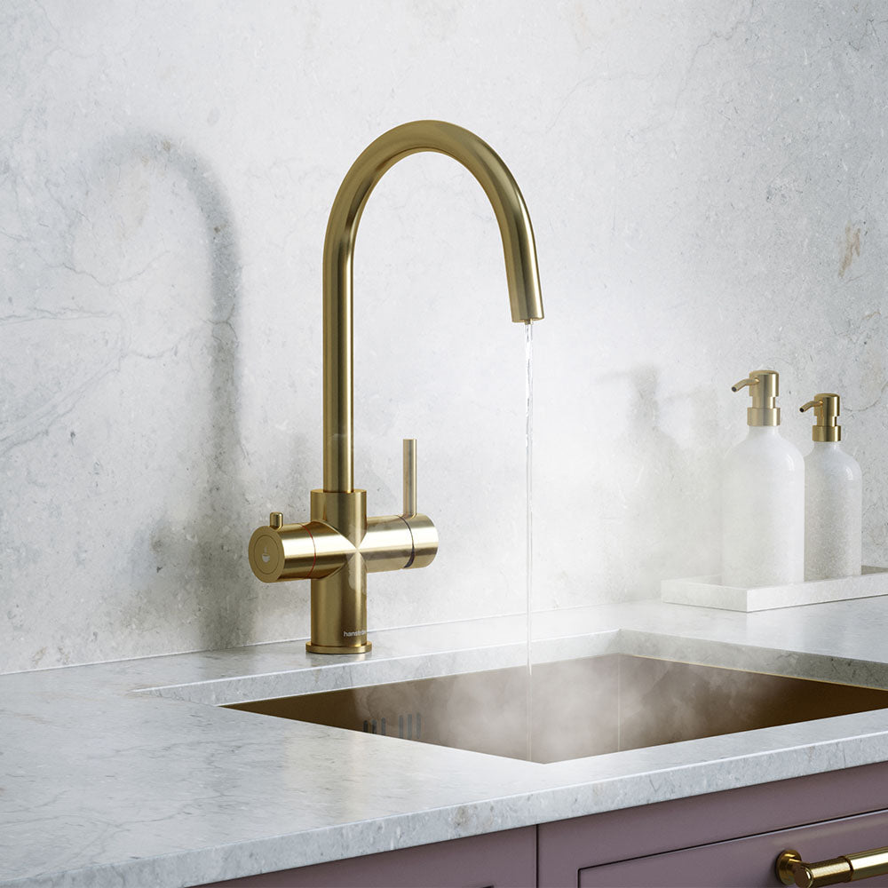 a brass swan neck boiling water tap on a white kitchen countertop