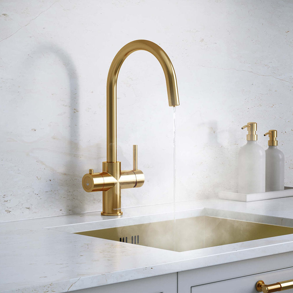 a gold swan neck boiling water tap on a white kitchen countertop