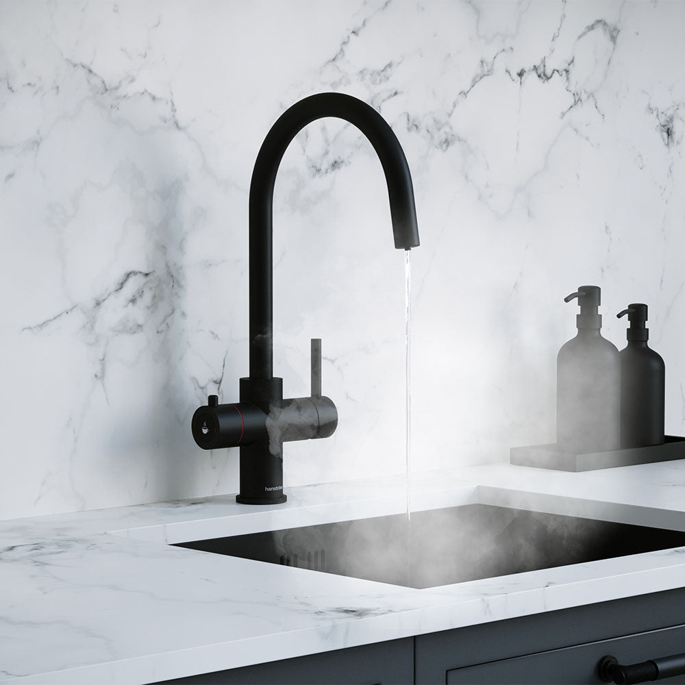 a matt black swan neck boiling water tap on a white kitchen countertop