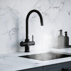 a matt black swan neck boiling water tap on a white kitchen countertop