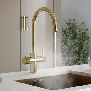 a brushed brass swan neck boiling water tap on a white kitchen countertop
