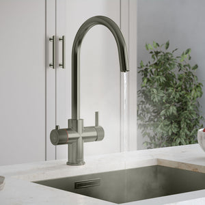 a gunmetal grey swan neck instant hot tap on a white kitchen countertop